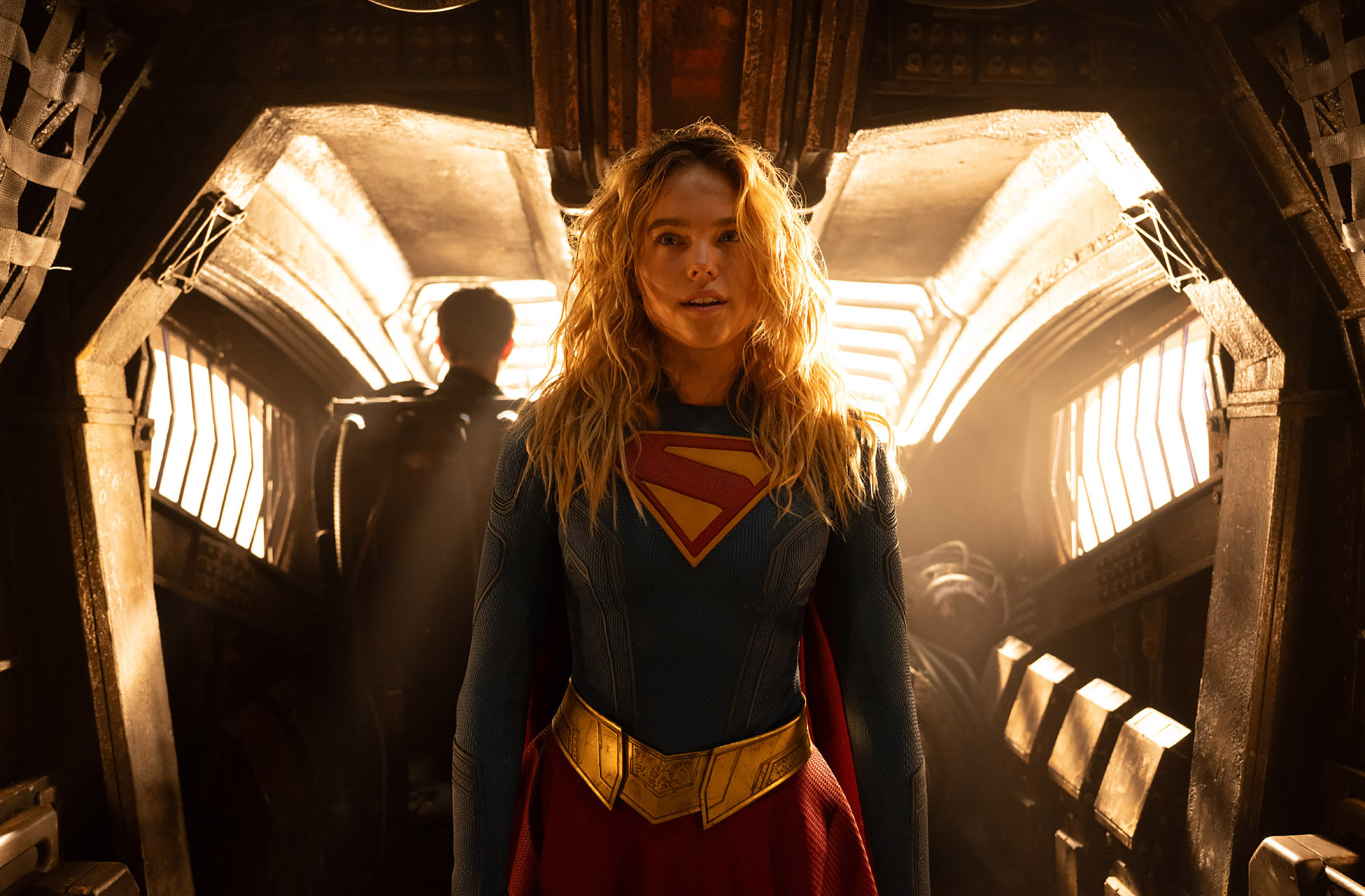 Milly Alcock como Kara Zor-El en el traje de Supergirl con el cielo estrellado de fondo